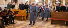 Wnętrze kościoła w Porębie, poczty sztandarowe, w ławkach pozostali uczestnicy uroczystości.