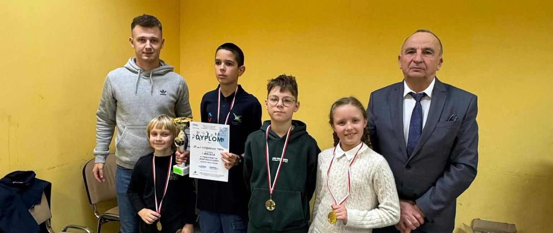 Zwycięska drużyna ze Szkoły Podstawowej nr 1 w Dąbrowie Tarnowskiej po dekoracji medalowej z Wicestarostą Dąbrowskim oraz nauczycielem wychowania fizycznego