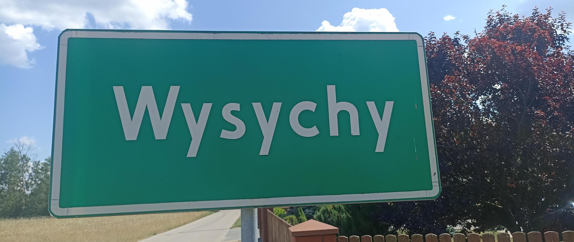 Prostokątna zielona tablica drogowa z nazwą miejscowości Wysychy