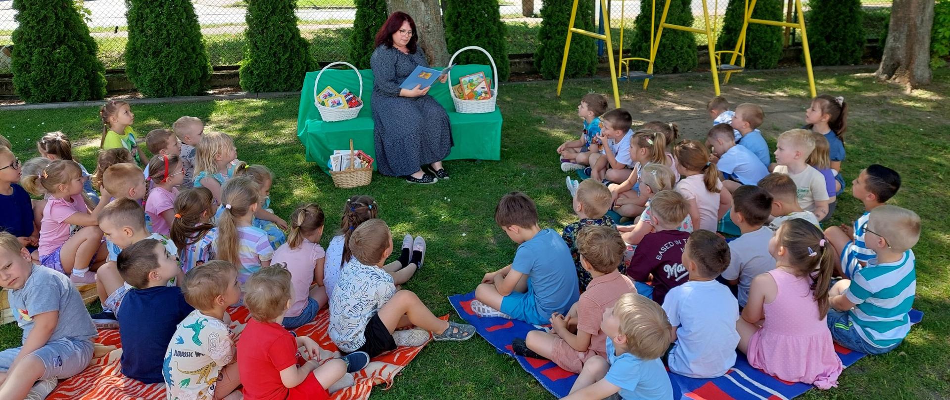 Nauczyciel z książką i grupa dzieci