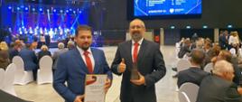 Etatowy członek zarządu Paweł Mostowy oraz starosta przasnyski Krzysztof Bieńkowski prezentują dyplom i statuetkę lidera wydatków inwestycyjnych w Polsce