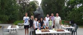 Uczestnicy zawodów pozują przy pomniku żubra