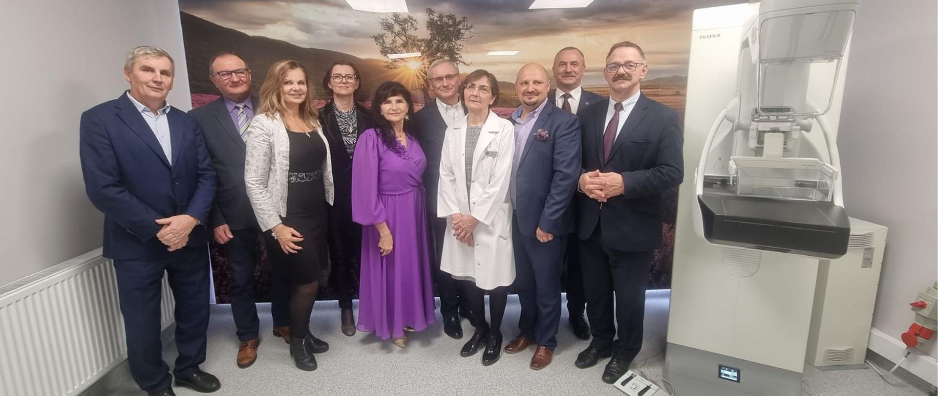 Uczestnicy wydarzenia stoją obok nowego mammografu.