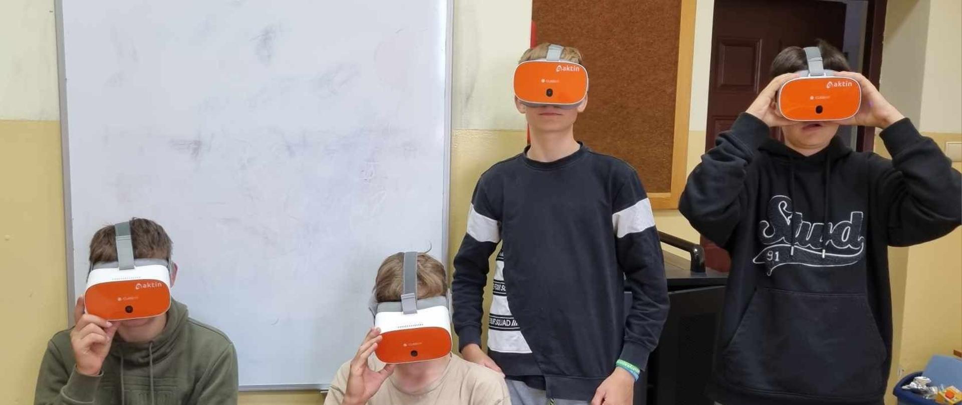 Uczniowie w okularach 3D w pracowni komputerowej.