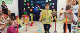 Dzieci ubrane w przygotowane przebrania z recyklingu, idą po "wybiegu" - kolorowym dywanie