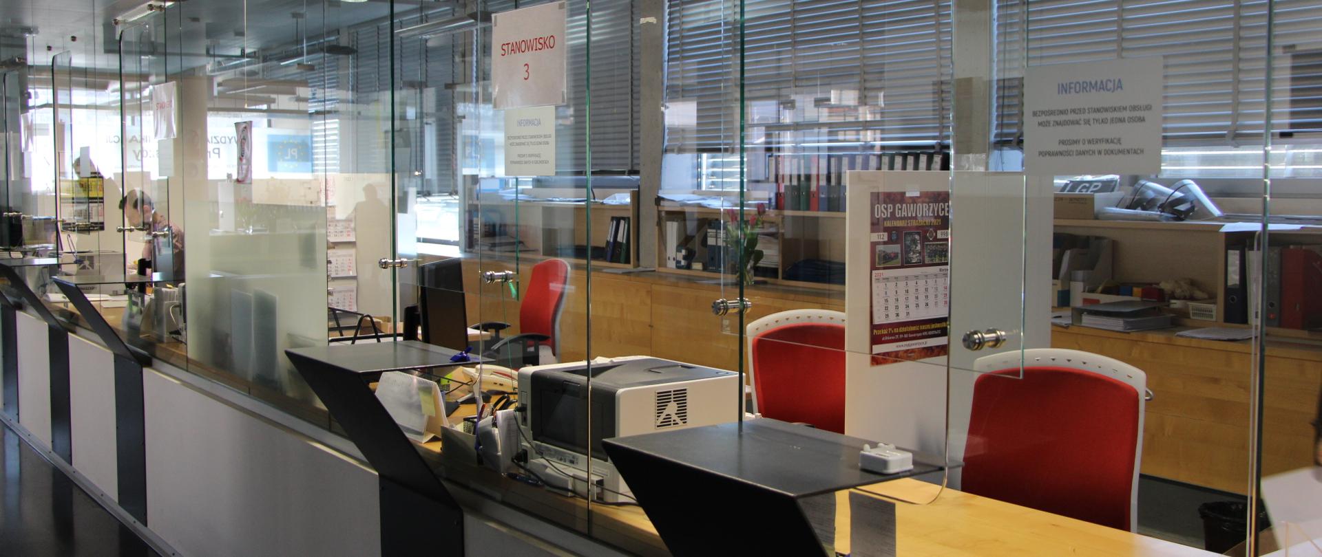 Na zdjęciu czerwone krzesła oraz lada służąca do obsługi Interesariuszy Wydziału Komunikacji Powiatu Polkowickiego