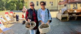 Panie stoją i trzymają koszyk pełen grzybów