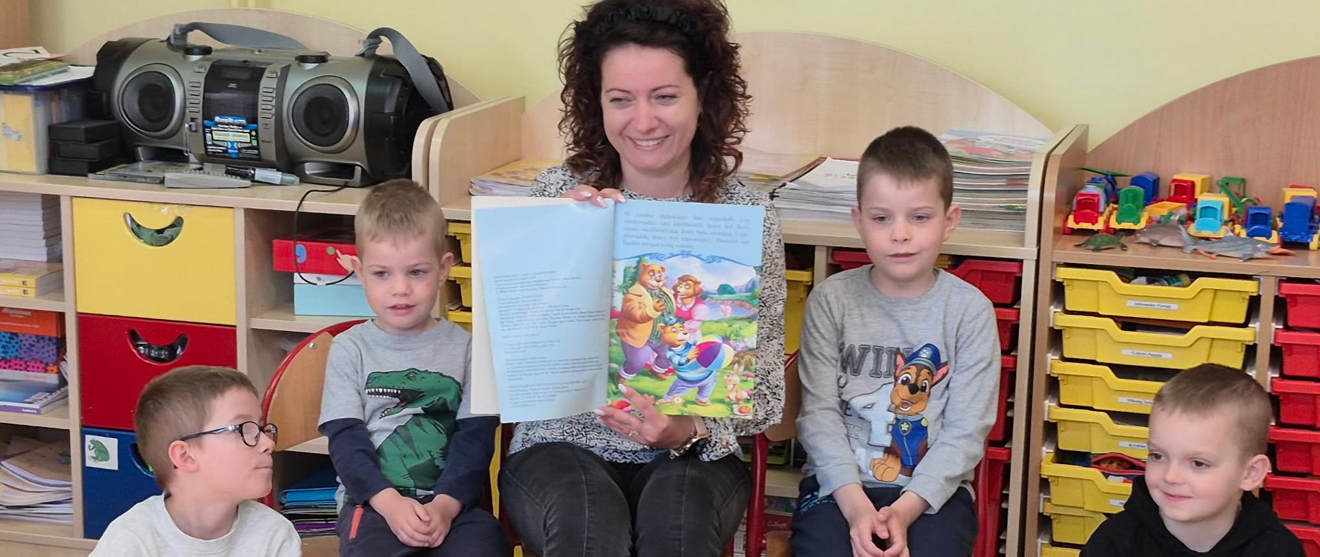 Pani Kasia pokazuje dzieciom ilustracje z czytanej bajki