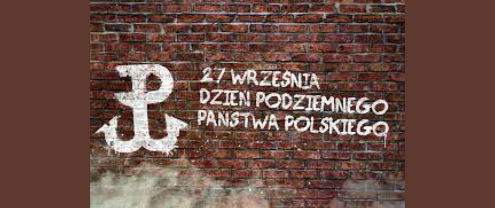 Biały napis - 27 września Dzień Podziemnego Państwa Polskiego z grafiką Znaku Polski Walczącej na ceglanym murze