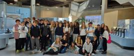 Wszyscy uczestnicy wycieczki z klas 6,7, 8a i 8b do Podkarpackiego Centrum Nauki- Łukasiewicz na tle wystawy o lotnictwie.