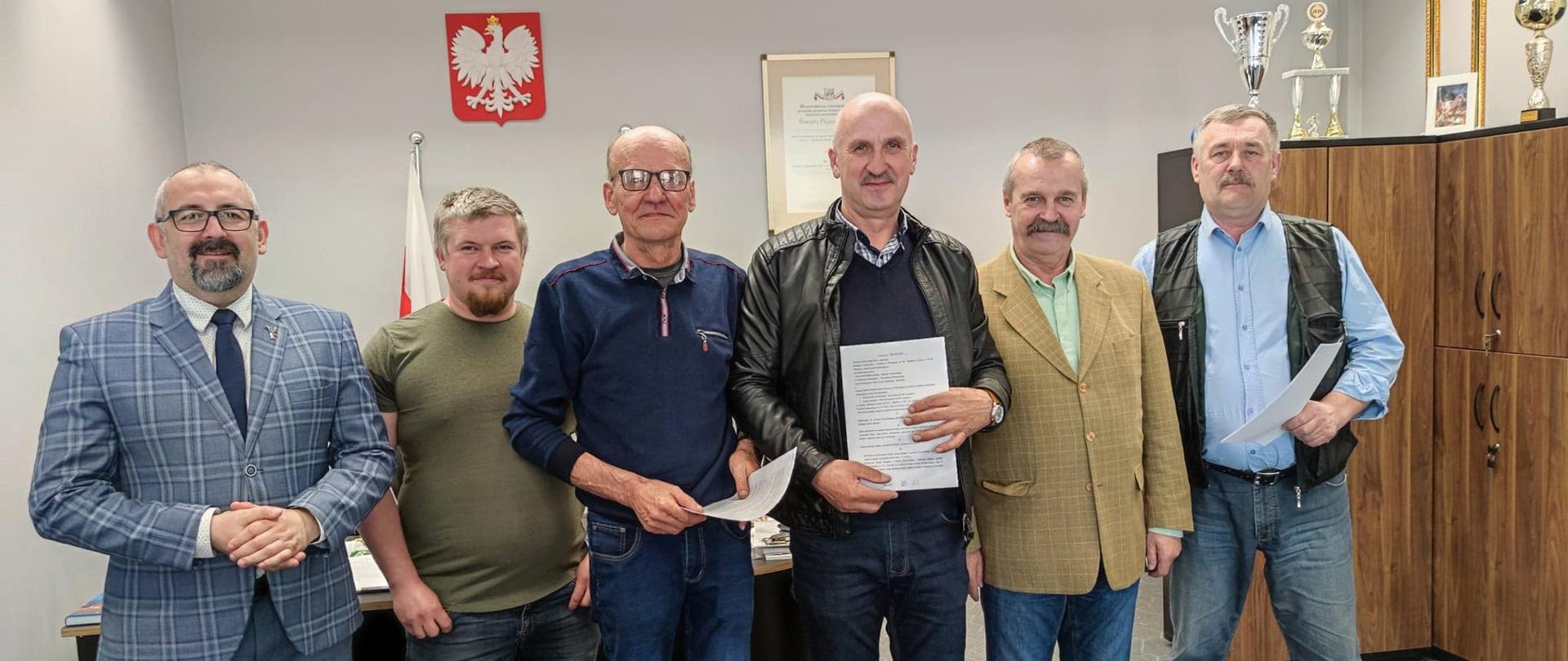 Zdjęcie przedstawia przedstawicieli gminnych spółek wodnych z miasta Przasnysz, Krasnego oraz Czernic Borowych, Starostę Przasnyskiego Krzysztofa Bieńkowskiego (pierwszy od lewej) i Wicestarostę Waldemara Trochimiuka (drugi od prawej). Fotografia wykonana w gabinecie Starosty Przasnyskiego.