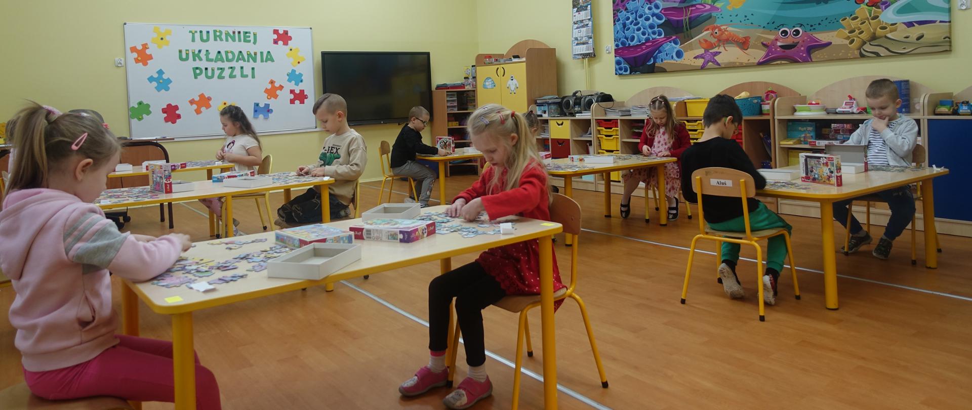Starszaki układają puzzle