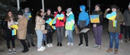 Młodzi uczestnicy wiecu z flagami Ukrainy