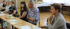 Nauczyciele biorący udział w szkoleniu siedzą przy stole