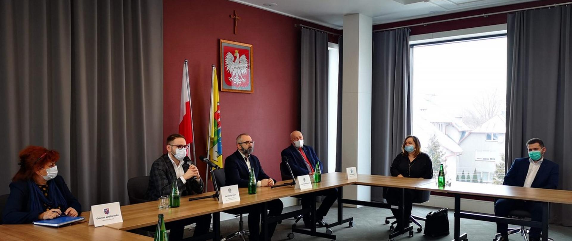 Sala konferencyjna w Centrum Aktywizacji Biznesu w Starostwie Powiatowym w Przasnyszu, Od lewej Wójt Gminy Przasnysz Grażyna Wróblewska, Minister Bartłomiej Orzeł, Starosta Przasnyski Krzysztof Bieńkowski, Wójt Gminy Krzynowłoga Mała Jerzy Humięcki wraz z pracownicą Urzędu Gminy, Etatowy Członek Powiatu Przasnyskiego Paweł Mostowy.