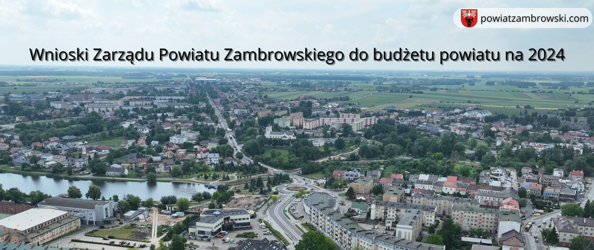 zdjęcie z lotu ptaka Miasta Zambrów na górze znajduje się tekst Wnioski Zarządu Powiatu Zambrowskiego do budżetu powiatu na 2024, w górnym prawym rogu logo powiatu z napisem powiatzambrowski.com, a w dolnym prawym rogu fot. Marcin Maciejewski