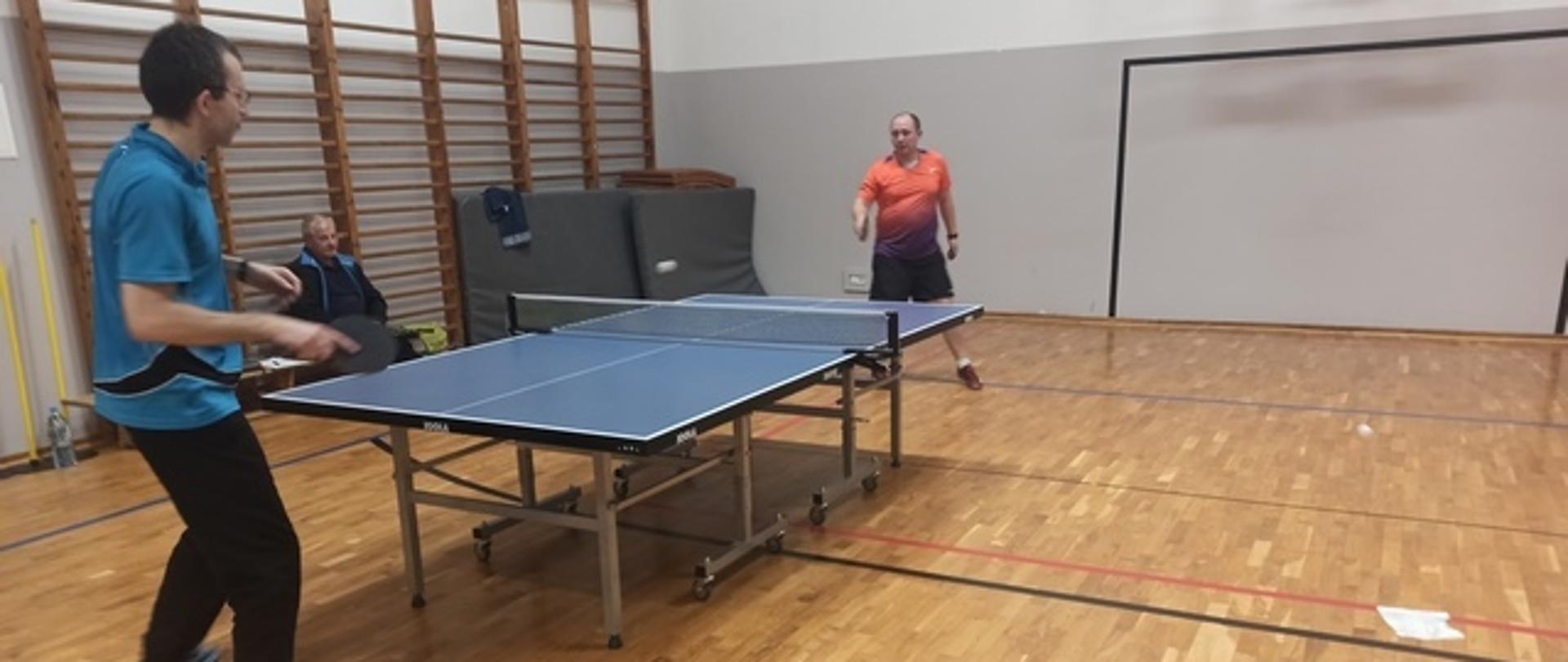 Akcja meczowa - dwóch mężczyzn przy stole tenisowym