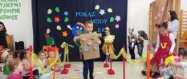 Dzieci ubrane w przygotowane przebrania z recyklingu, idą po "wybiegu" - kolorowym dywanie