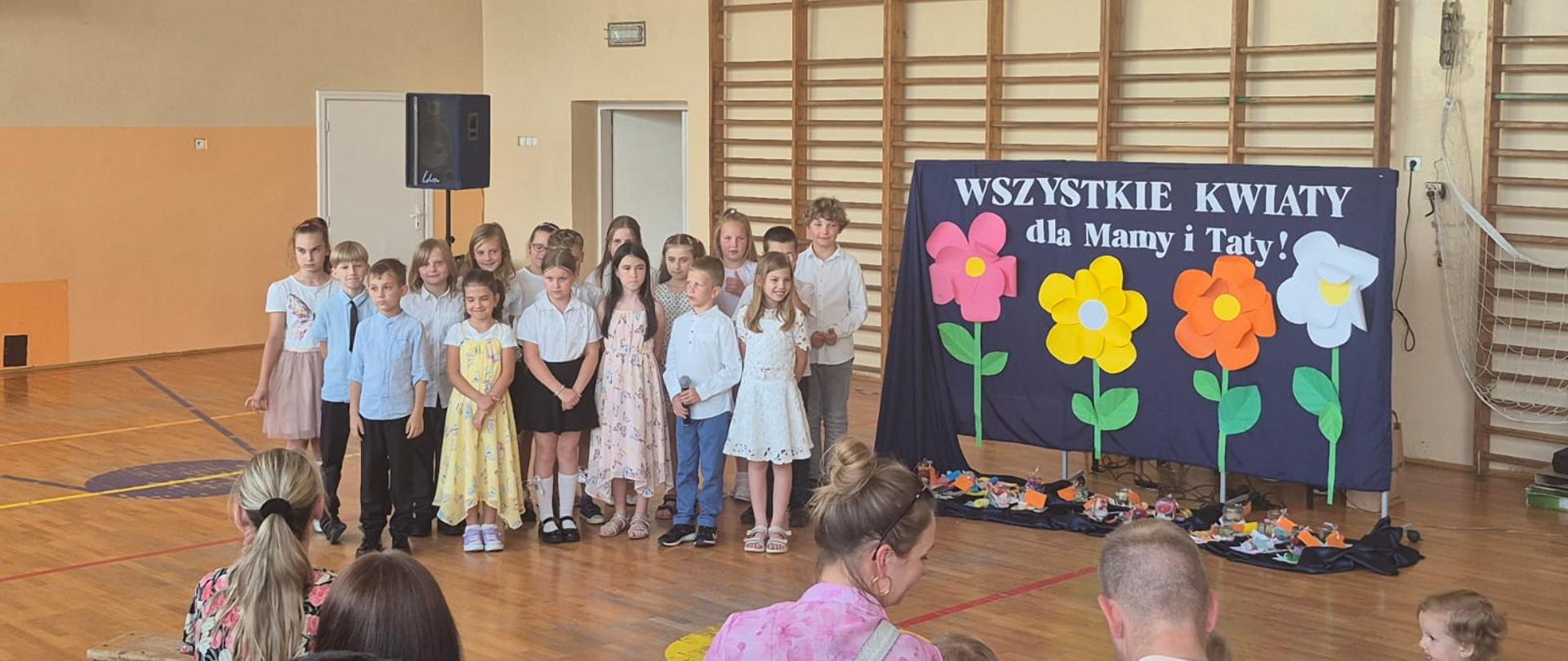 Uczniowie klasy 2 b podczas występu - obok tablica z dekoracją.