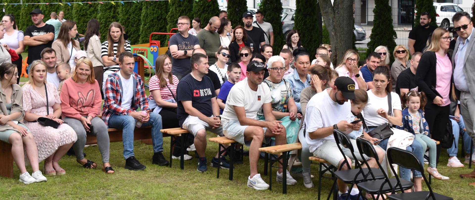 Na zdjęciu są widoczni rodzice, którzy przyszli na Piknik Rodzinny do Żłobka Miejskiego w Sokołowie Podlaskim by obejrzeć występy swoich pociech.