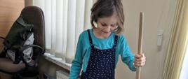Podczas ćwiczeń z koordynacji ruchowej - dziewczynka stoi na małej podkładce ułożonej na podłodze