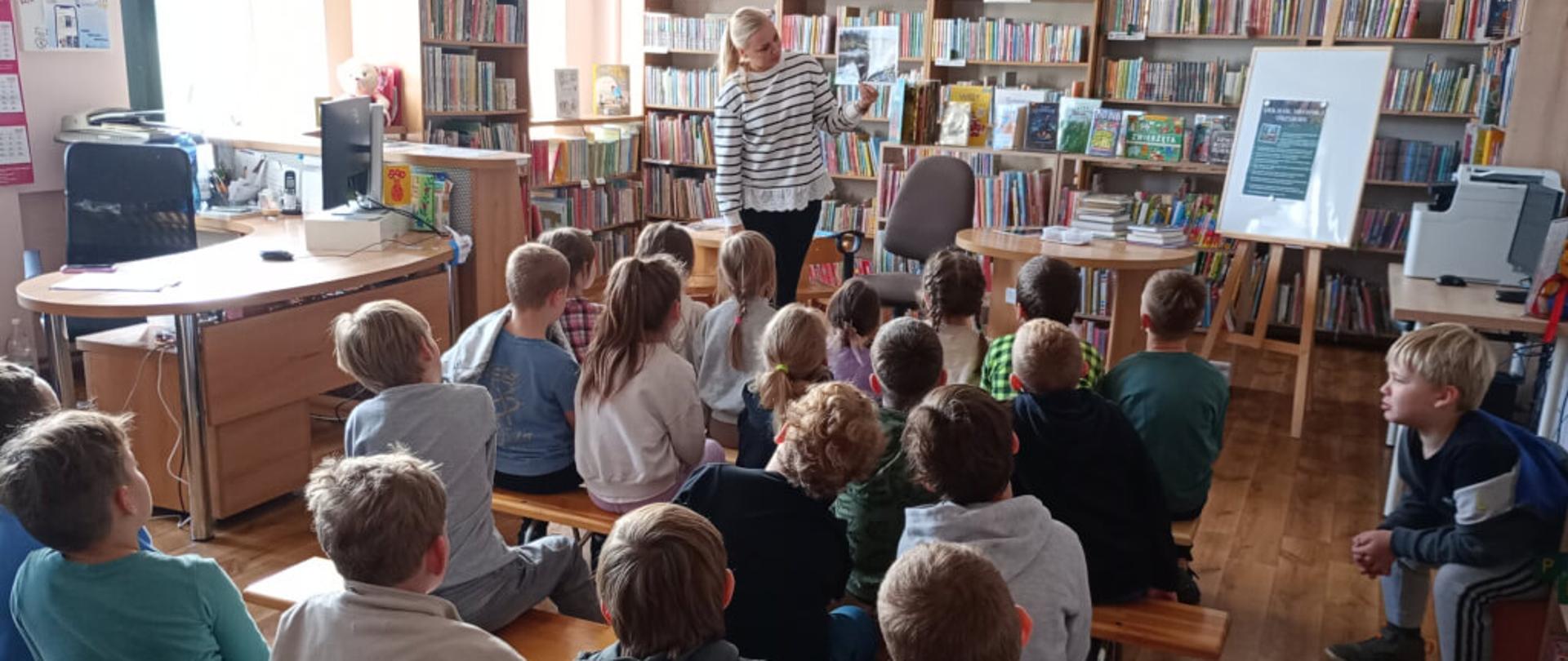 Zdjęcie przedstawia dzieci, które rozmawiają na temat naturalnego cyklu życia ptaków wędrownych na przykładzie polskiego Kopciuszka.