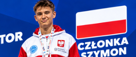 Szymon Członka w półzbliżeniu na niebieskim tle, na którym jest flaga Polski