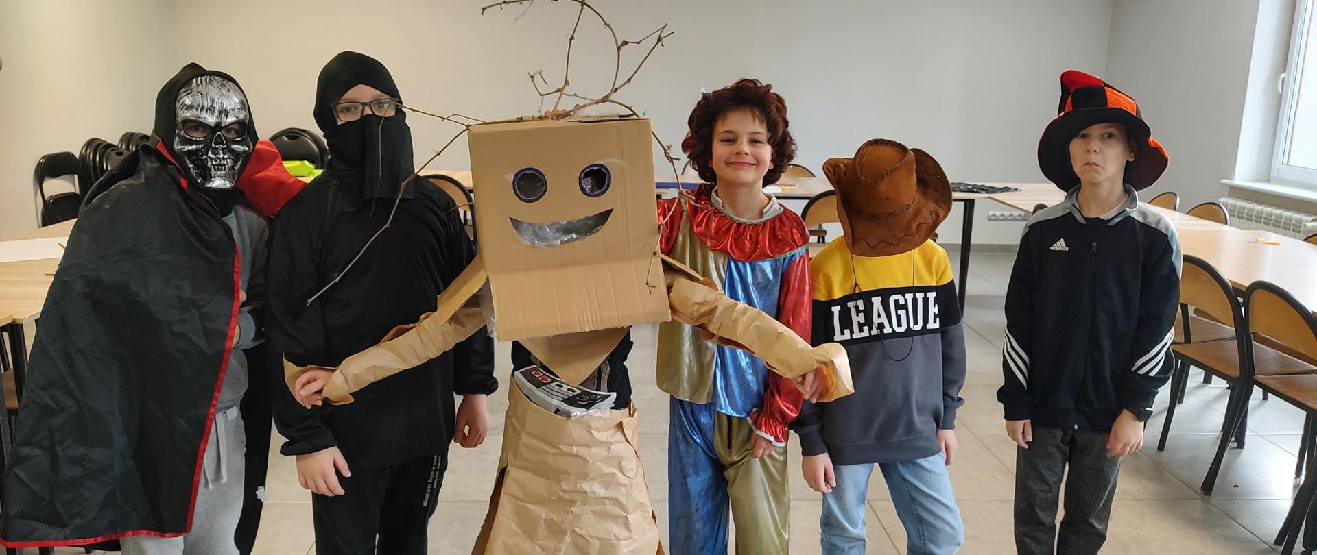 6 dzieci przebrało się w: od lewej: w kościotrupa z peleryną, ninja, Groota, klauna, kowboja i czarodzieja, gdzie elementy ubioru powstały między innymi z kartonu, krepy, gałęzi i taśmy klejącej.