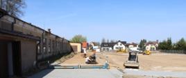 Plac budowy - widok pracowników przy pracy oraz maszyny budowlane