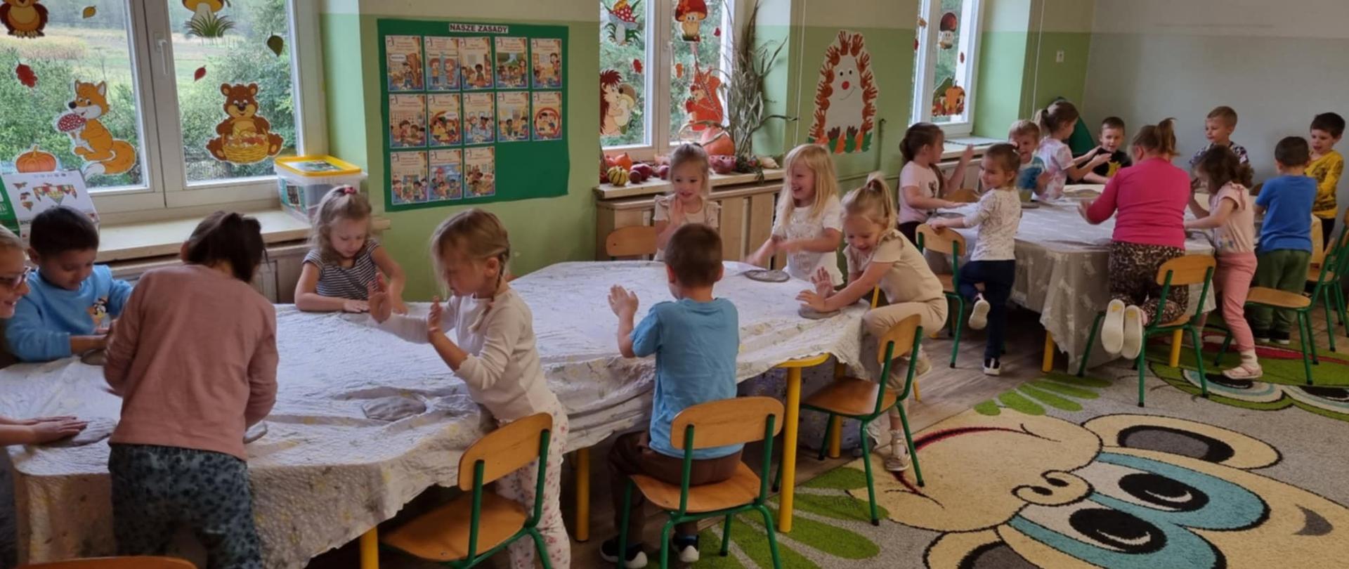 Dzieci uczestniczą w warsztatach ceramicznych. Wyrabiają glinę.