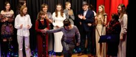 Przedstawianie wykonawców, wszyscy razem na scenie biją brawo, jedna solistka się kłania.