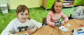 Dwie uczennice wykonują za pomocą długopisów 3D śnieżynki 
