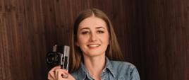 Kobieta z aparatem fotograficznym w prawym ręku