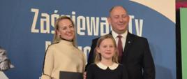 Karolina pozuje do zdjęcia z organizatorem konkursu i nauczycielką śpiewu