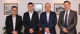 Na zdjęciu w gabinecie, na tle ściany z obrazkami wykonano zdjęcie, na którym widzimy starostę sokołowskiego, wicestarostę oraz dotychczasowego i nowego Powiatowego Inspektora Nadzoru Budowlanego.