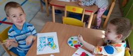 Dzieci pozują do zdjęcia nad kolorowankami