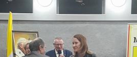 Od lewej- Wiceprzewodniczący Gustaw Dmowski gratuluje Aleksandrze Kiepuszewskiej (sołtys wsi Suchodołek, w ręku trzyma list gratulacyjny). w oddali Burmistrz Jan Paweł Ługowski przemawia.