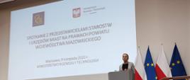 Zdjęcie przedstawia prelegentów z Ministerstwa Rozwoju i Technologii stojących i siedzących na scenie.