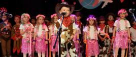 Grupa dzieci na scenie podczas występu z okazji Dnia Mamy i Taty