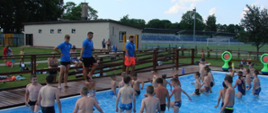 Uczestnicy zawodów w basenie - trenerzy wyjaśniają poszczególne konkurencje