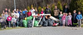 Grupa mieszkańców Bielanki po wydarzeniu zbierania śmieci na terenie miejscowości Bielanka przy workach ze śmieciami jakie nazbierali podczas akcji.