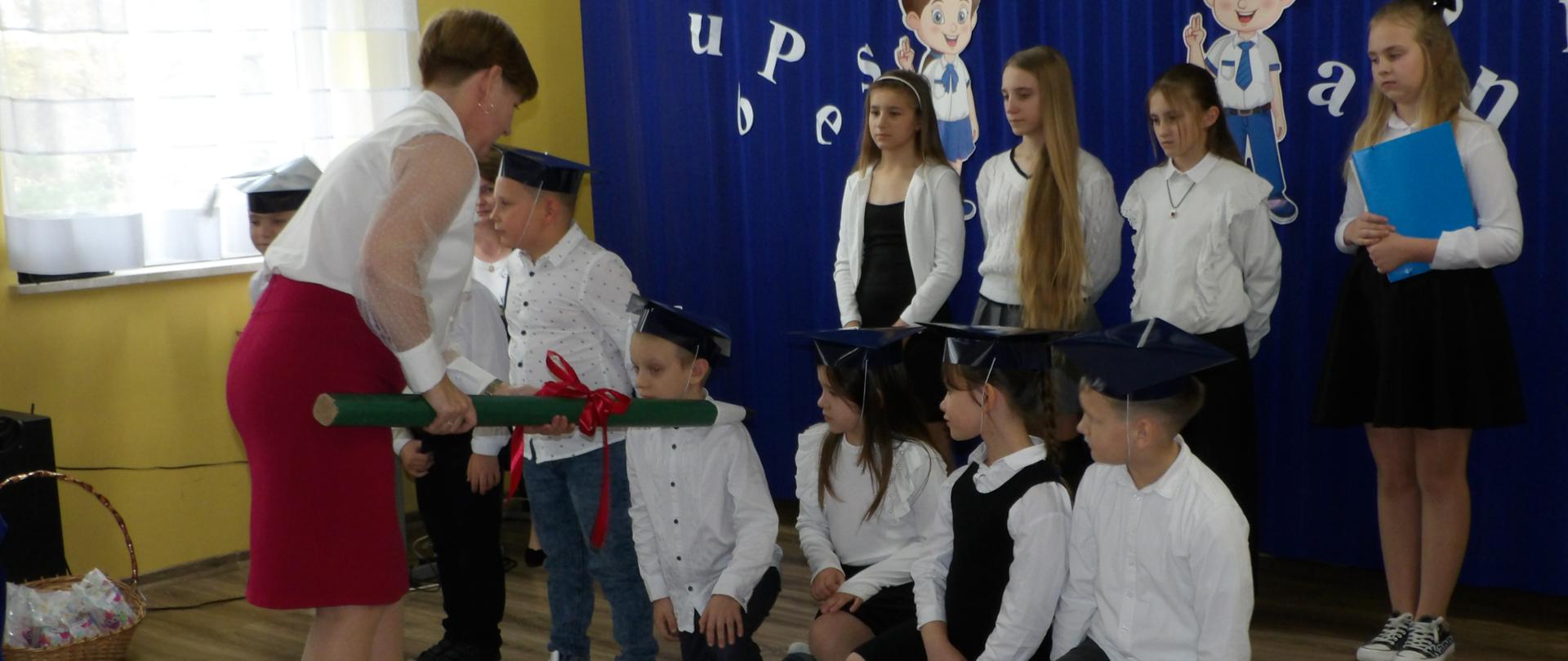 pasowanie na ucznia symbolicznym ołówkiem przez panią dyrektor 