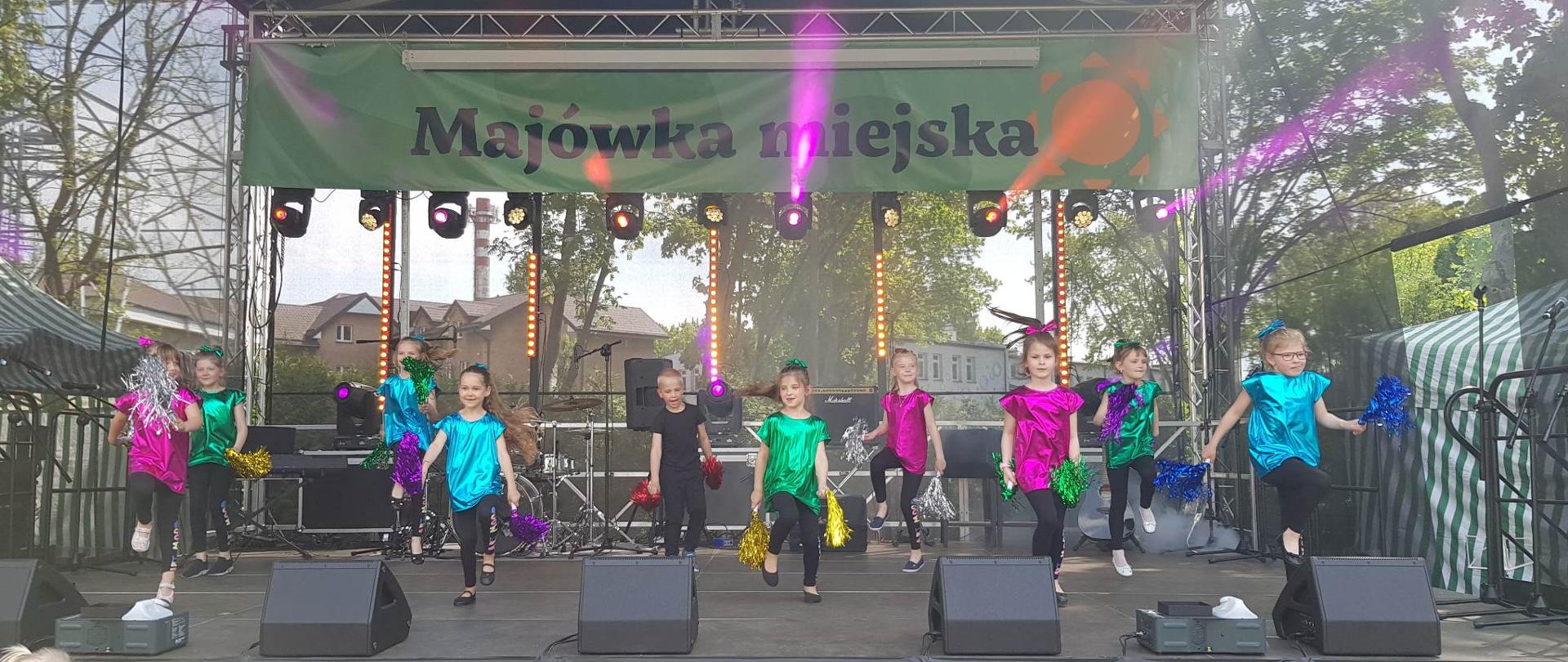 Dzieci w kolorowych strojach na scenie 
