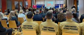 Osoby siedzą na widowni