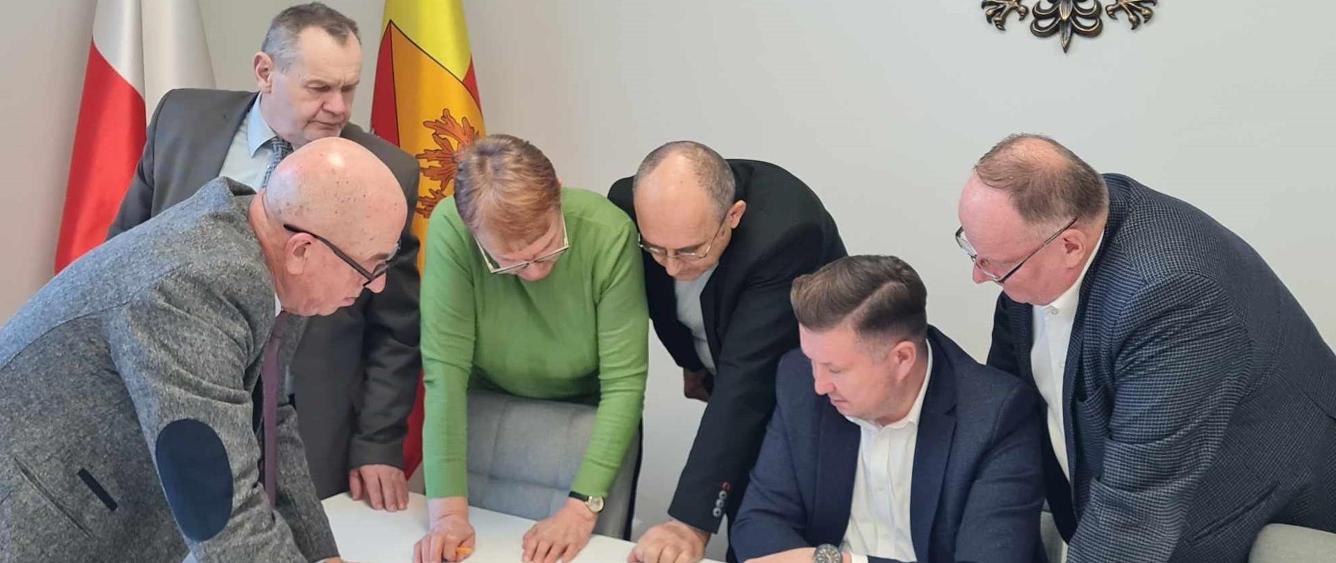 Posiedzenie zarządu - uczestnicy pochyleni nad mapą
