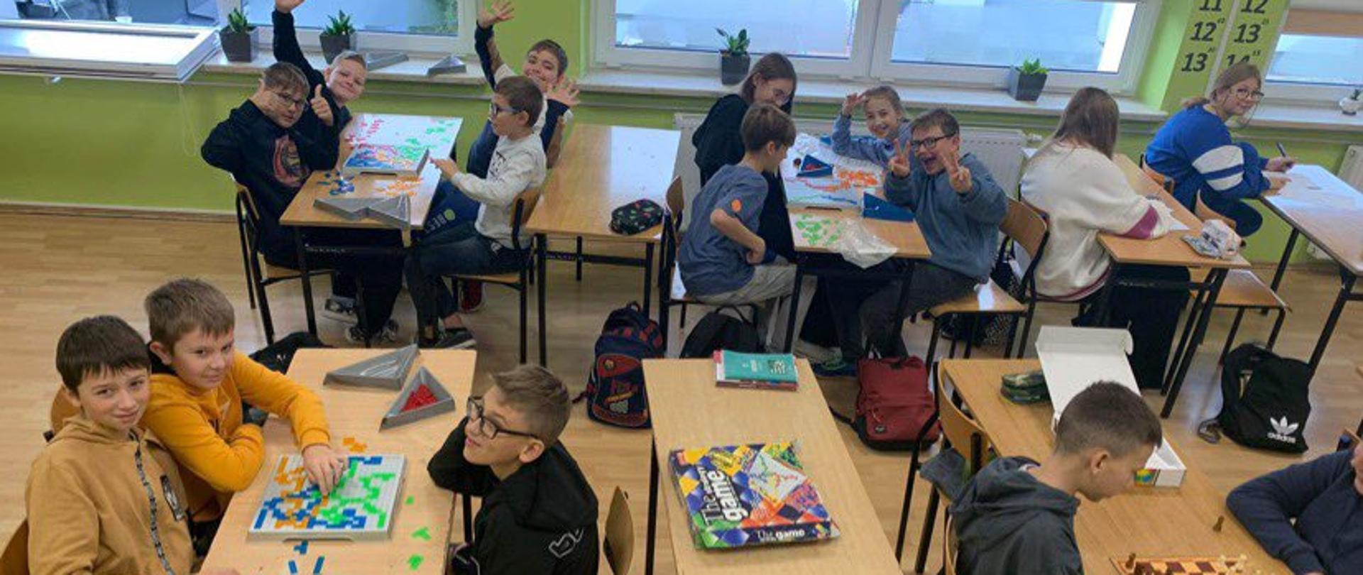dzieci w klasie grają w grupach w gry planszowe