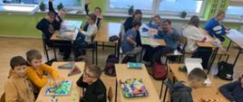 dzieci w klasie grają w grupach w gry planszowe