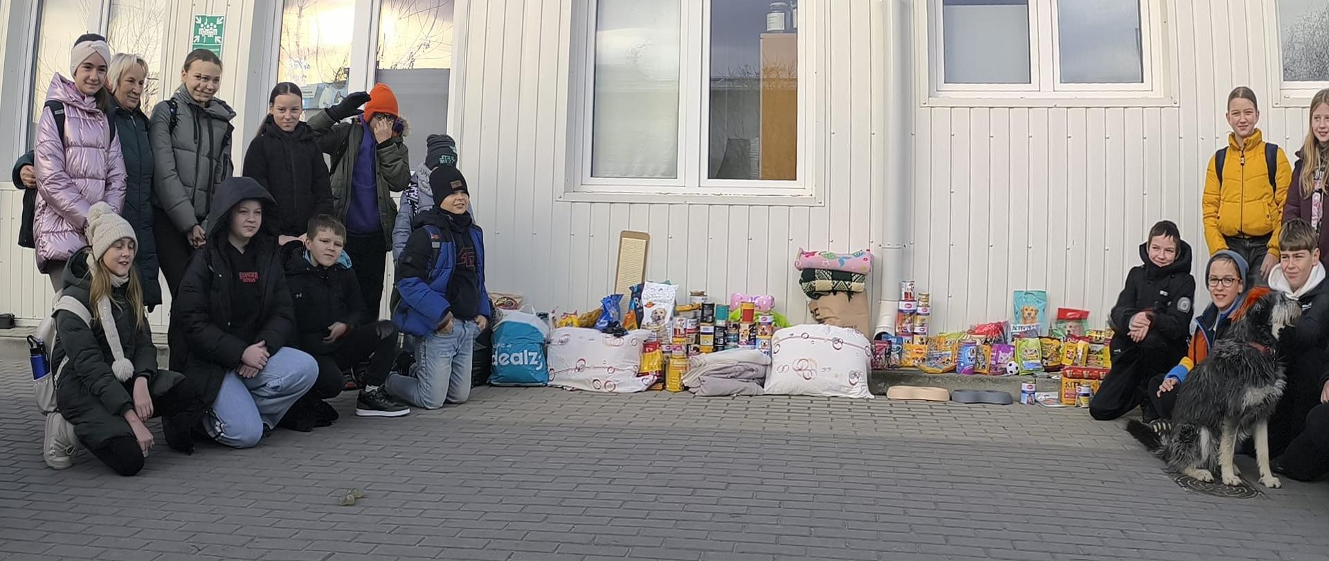 Uczniowie naszej szkoły z zebranymi darami przed budynkiem schroniska w Mielcu.