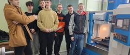 Uczniowie pozują przy maszynie