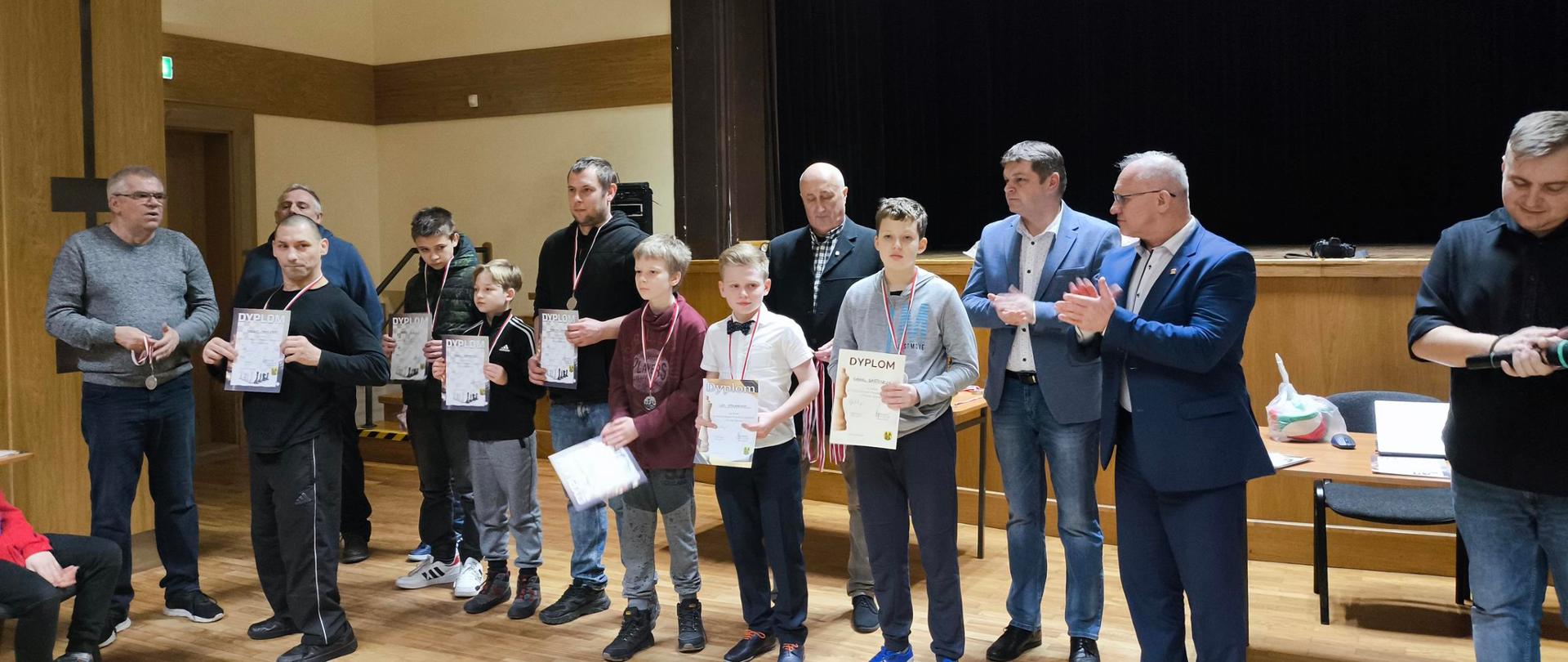 Uczestnicy turnieju z dyplomami i medalami pozują z Organizatorami do zdjęcia